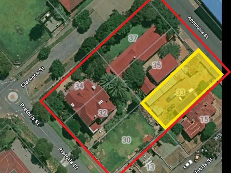 Aerial view of the commercial property site, highlighting the building layout, roof structure, and surrounding street access.