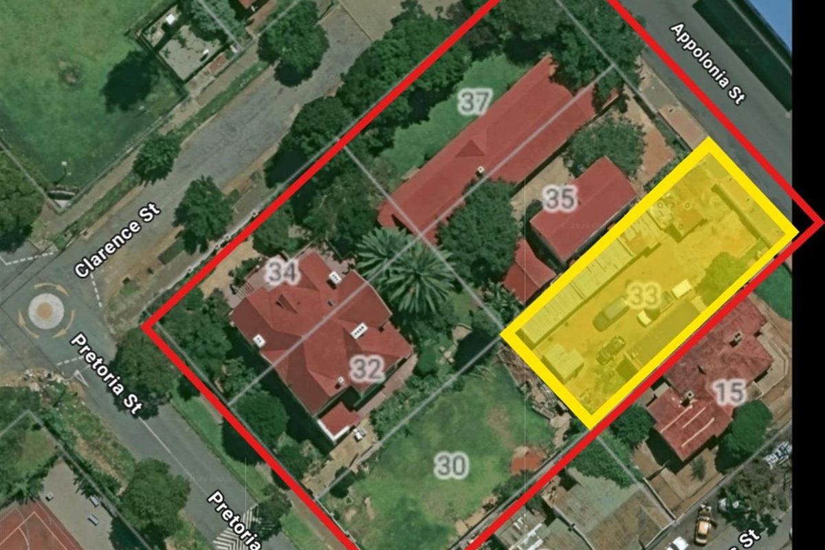 Aerial view of the commercial property site, highlighting the building layout, roof structure, and surrounding street access.
