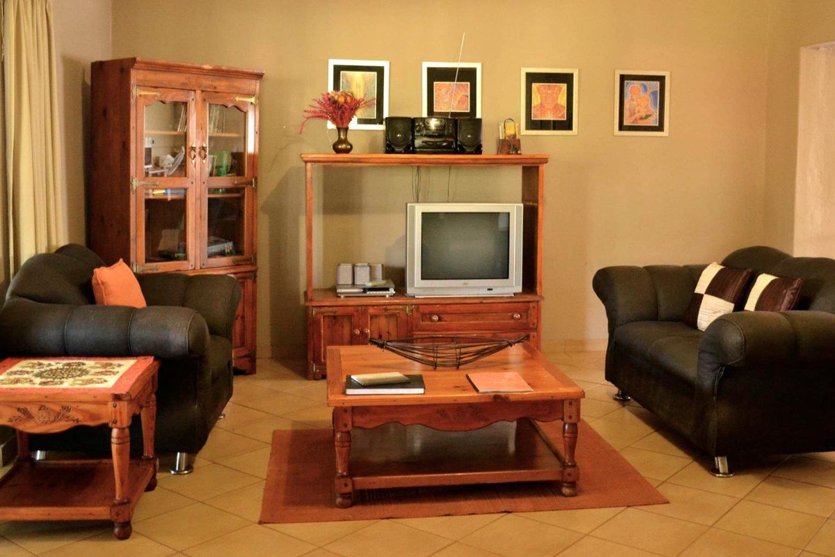 A comfortable living room featuring tiled flooring and neutral wall tones, providing a functional and inviting space for relaxation.