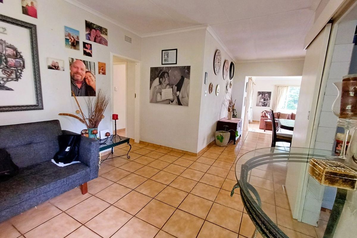 Open-plan living area featuring neutral ceramic floor tiles and a built-in sliding door cupboard, providing a functional and connected layout.