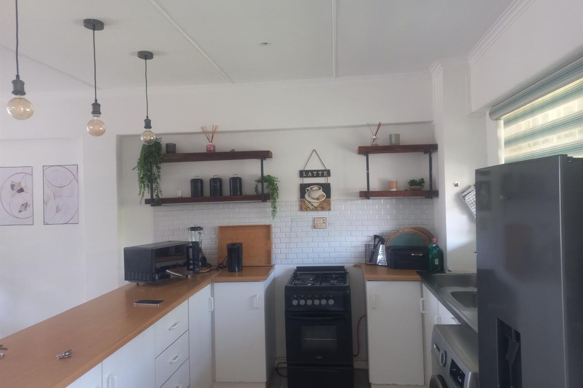 A functional kitchen featuring white cabinetry, wooden countertops, subway tile backsplash, open shelving, and a built-in oven with a gas hob.