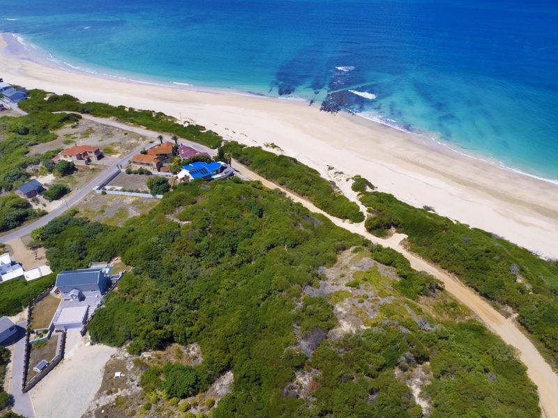 An aerial view of the coastal residential area, showcasing the proximity to the beach and surrounding natural vegetation.