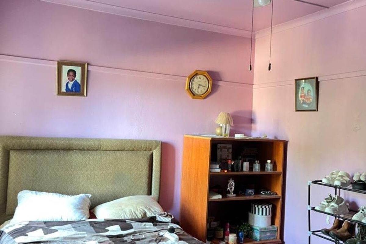 A bedroom featuring a ceiling fan and tiled flooring, providing a functional space with potential for cosmetic updates.