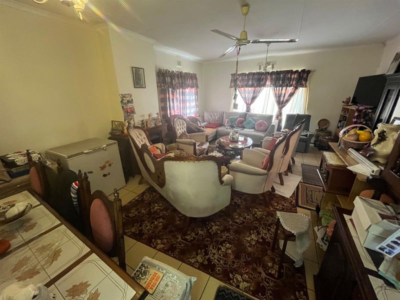 Spacious open-plan living and dining area featuring tiled flooring and a ceiling fan, providing a functional layout for family gatherings.
