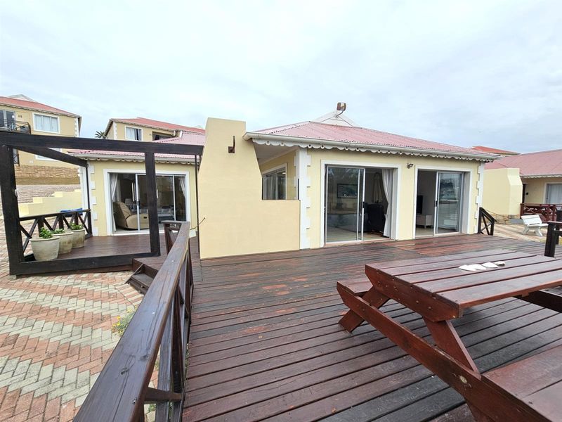 Spacious outdoor timber deck featuring a built-in fireplace, providing an ideal area for alfresco dining and entertaining with direct access to the living spaces.