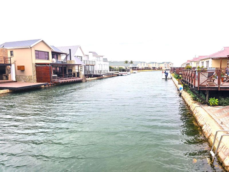A scenic view of a residential canal estate featuring waterfront homes with private decks and direct water access.