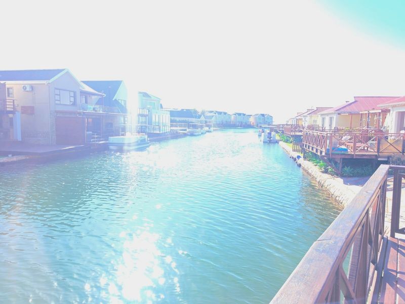 A scenic view of a residential canal estate featuring waterfront homes with private decks and direct water access.