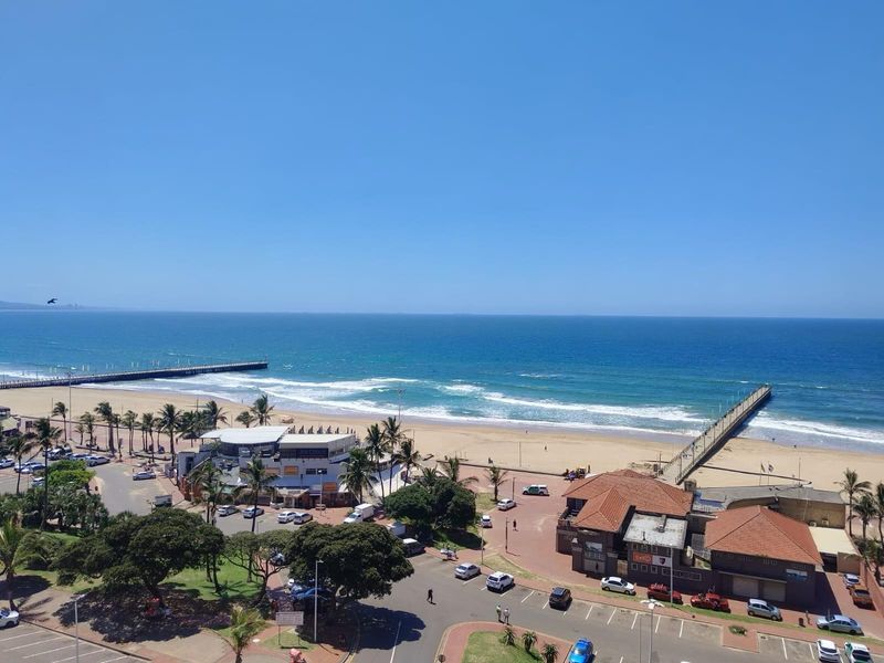 Elevated coastal view overlooking the beach, ocean, piers, and surrounding seaside infrastructure.