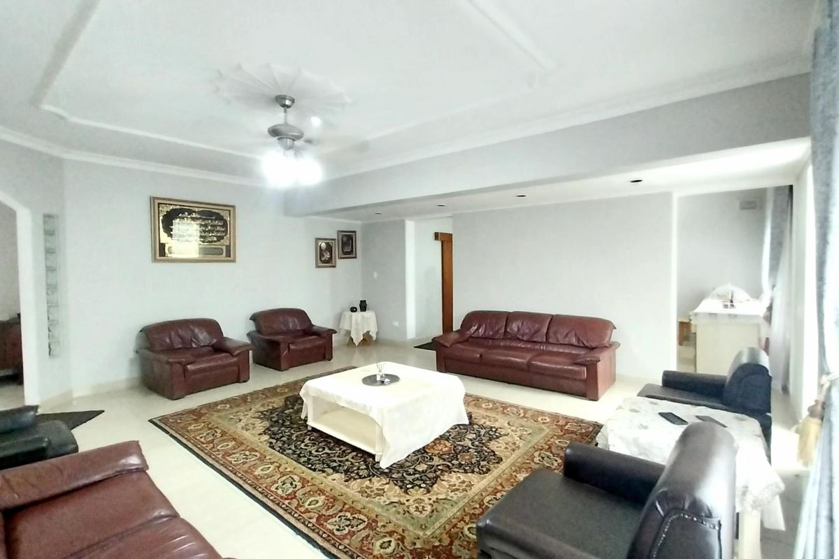 Spacious living room featuring a decorative ceiling rose, recessed lighting, and a ceiling fan, providing a comfortable and well-lit area for relaxation.