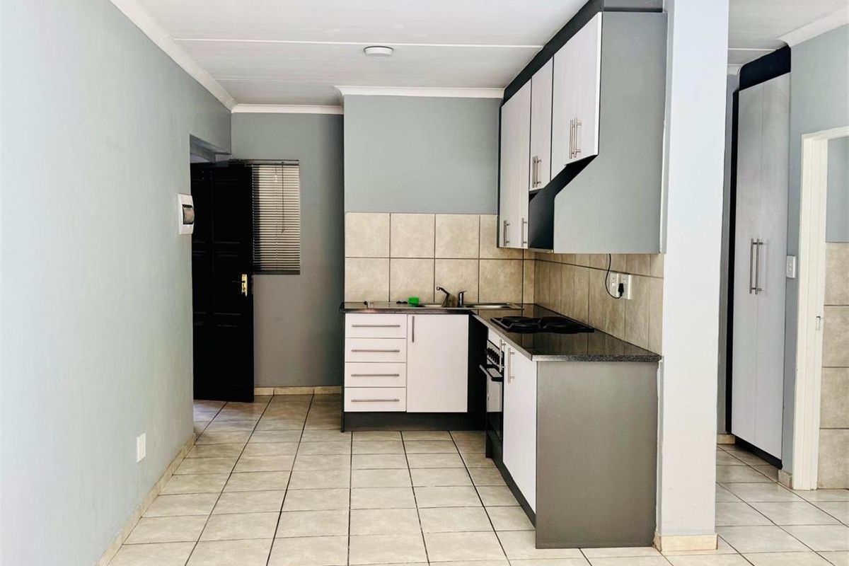 A functional kitchen featuring built-in cabinetry, a tiled backsplash, a built-in oven with hob, and tiled flooring in an open-plan layout.