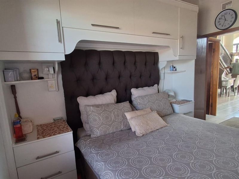 Bedroom featuring built-in white cabinetry surrounding the bed area with integrated shelving and bedside storage.