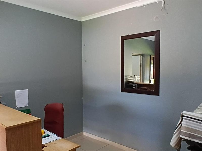 A functional office space featuring tiled flooring and neutral wall finishes, suitable for a home workspace or study area.