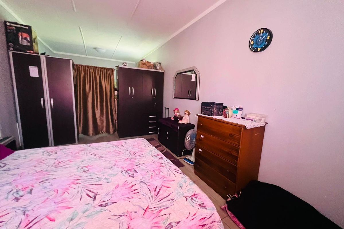 A functional bedroom featuring tiled flooring and standard ceiling finishes, providing a comfortable and practical living space.
