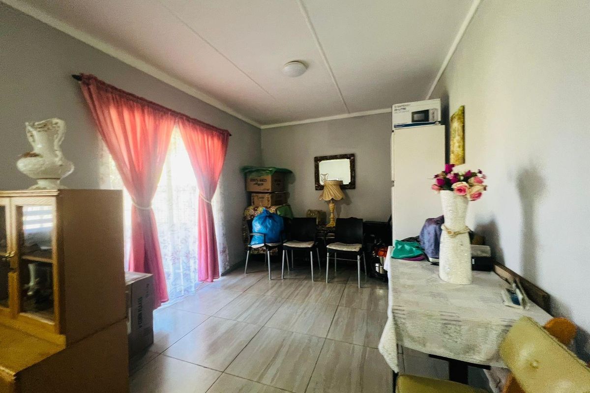 A living area featuring tiled flooring and sliding glass doors that provide access to the exterior.