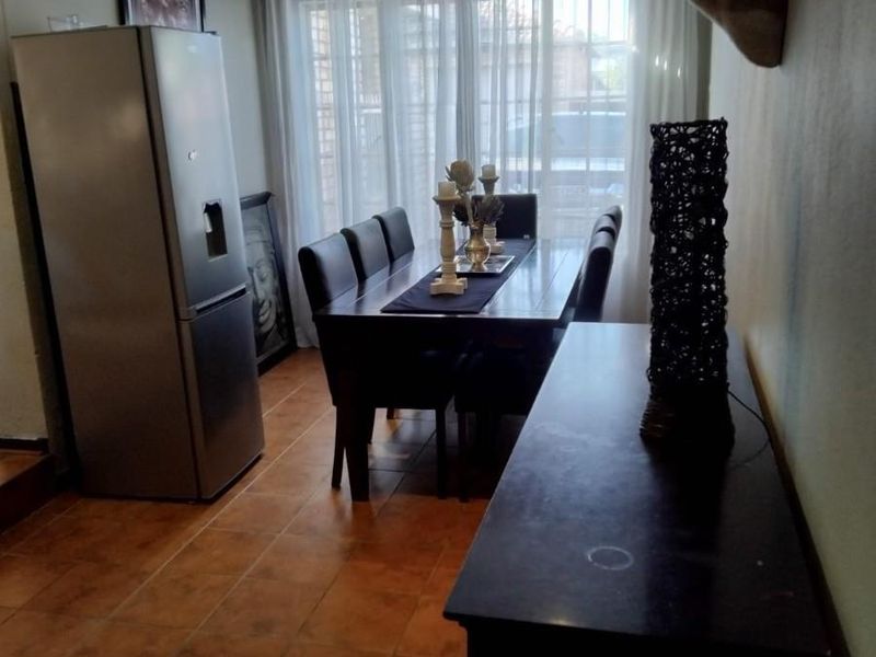 A dining room featuring tiled flooring, recessed downlighting, and a sliding glass door providing access to the exterior.