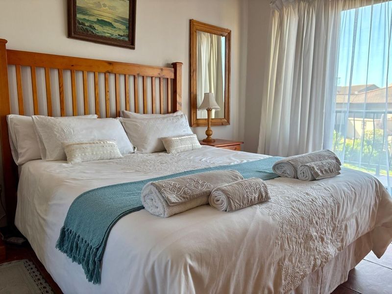 A well-lit bedroom featuring tiled flooring and a sliding glass door providing access to an outdoor balcony area.