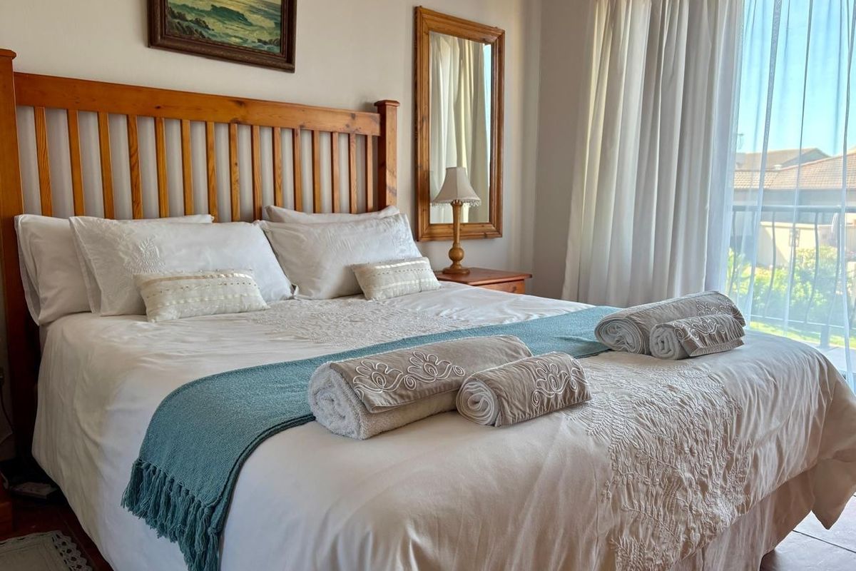 A well-lit bedroom featuring tiled flooring and a sliding glass door providing access to an outdoor balcony area.