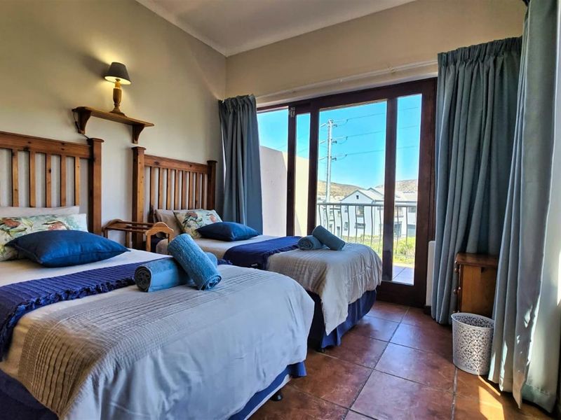 A bedroom featuring tiled flooring and large sliding glass doors that provide access to an outdoor balcony area.