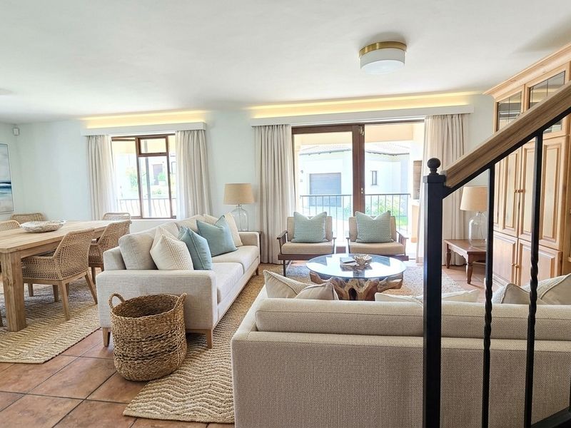 Spacious open-plan living and dining area featuring terracotta flooring, recessed lighting, and direct access to a patio through sliding glass doors.