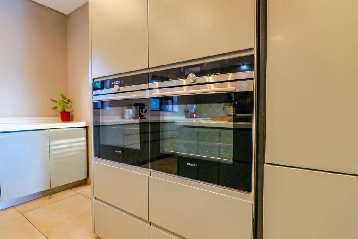 Modern kitchen featuring integrated Siemens double ovens and sleek cabinetry with clean lines and high-quality finishes.