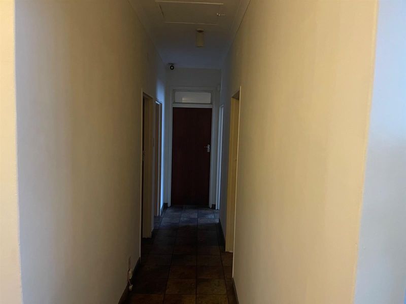 A functional interior hallway featuring tiled flooring and multiple doorways providing access to various rooms within the home.