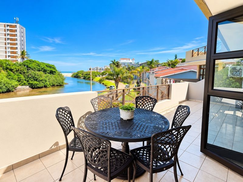 A spacious balcony featuring tiled flooring and a metal balustrade, offering scenic views of the river and surrounding landscape.