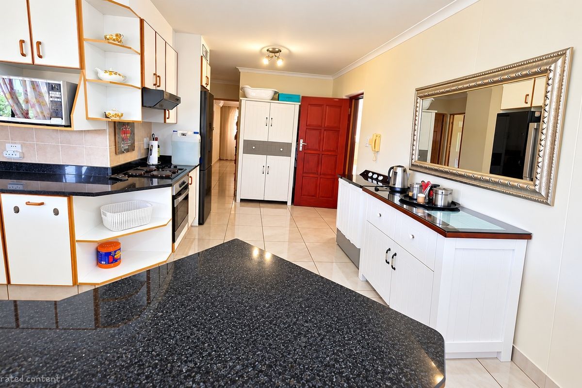 A functional kitchen featuring granite countertops, built-in cabinetry, and tiled flooring, offering a practical layout with integrated cooking appliances.