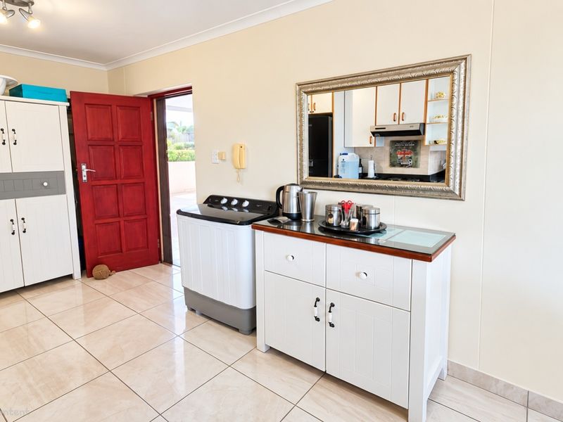 A functional laundry area featuring tiled flooring, built-in cabinetry, and direct access to an exterior door.