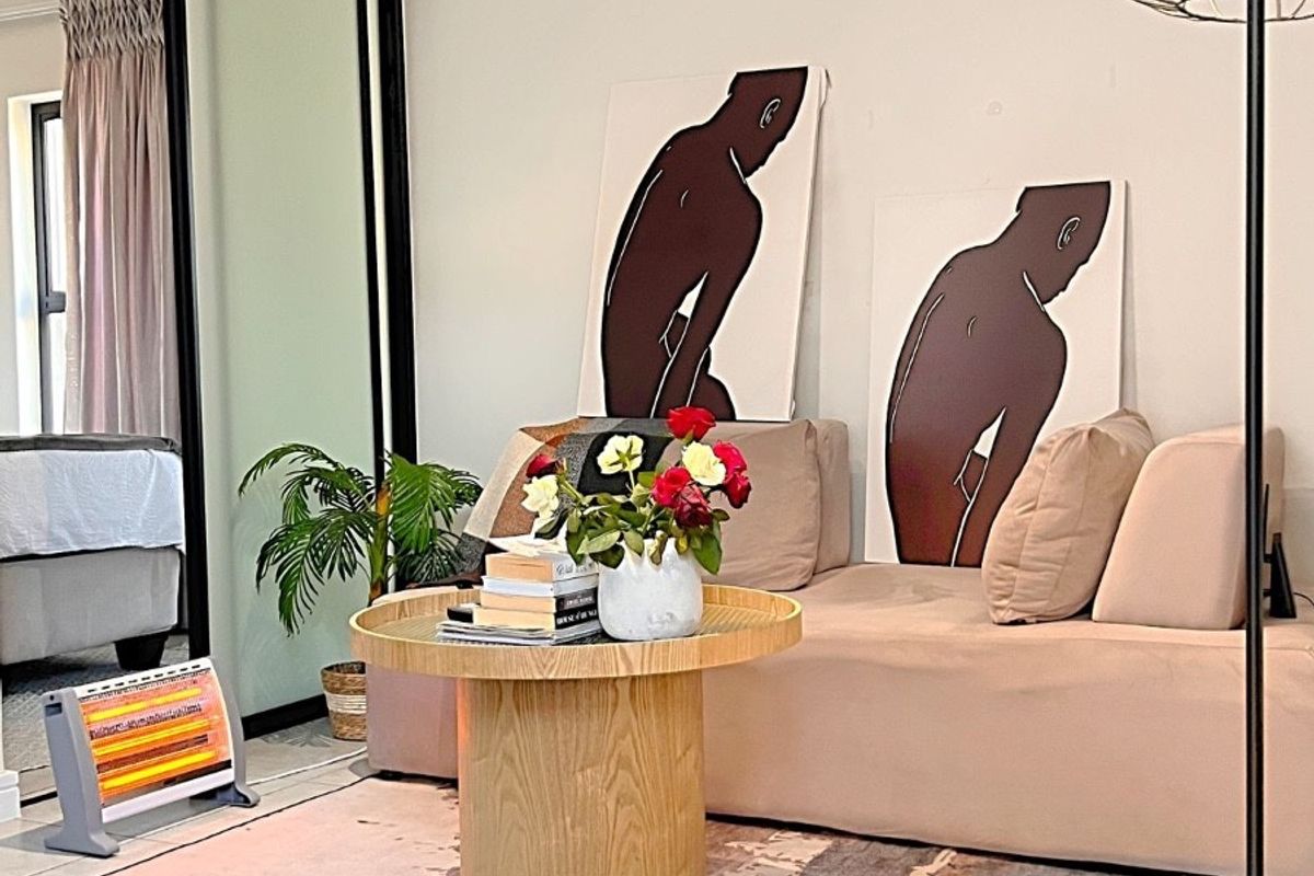 A well-maintained living area featuring neutral walls, tiled flooring, and a large sliding glass door providing access to an adjacent room.