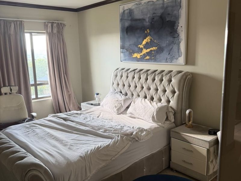 A well-lit bedroom featuring crown molding and a flush mount ceiling light, offering a comfortable and functional living space.