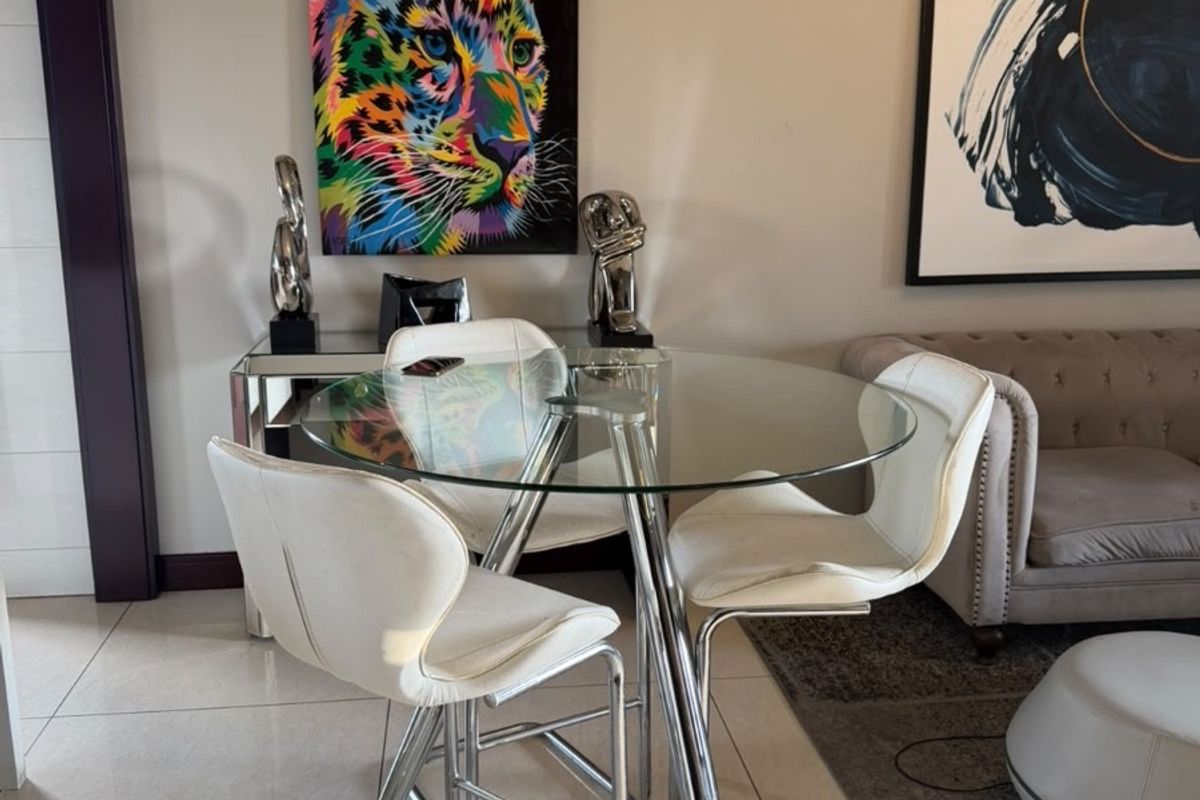 A well-maintained living area featuring neutral tiled flooring and dark crown molding, providing a clean and contemporary foundation for the space.