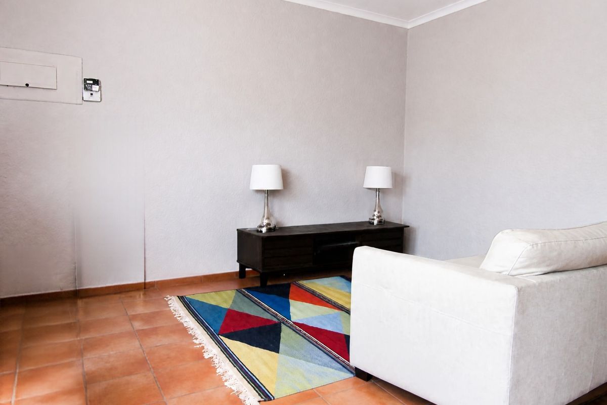 A living room area featuring terracotta floor tiles, a neutral wall finish, and integrated electrical and intercom infrastructure.