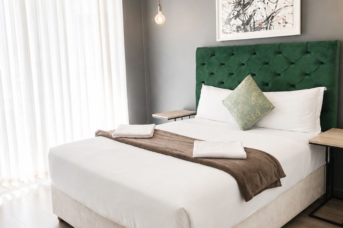 A well-maintained bedroom featuring modern laminate flooring and neutral wall finishes, providing a clean and comfortable living space.