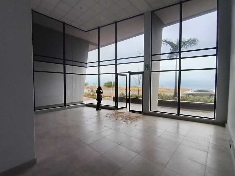 Spacious, light-filled retail entrance area featuring floor-to-ceiling glass windows, tiled flooring, and a modern open-plan layout.