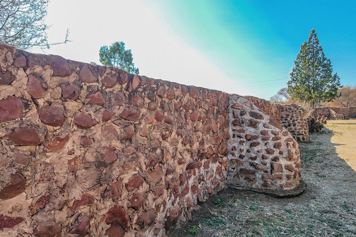 A rustic stone boundary wall and retaining structure located on the farm property, showing signs of age and weathered masonry.
