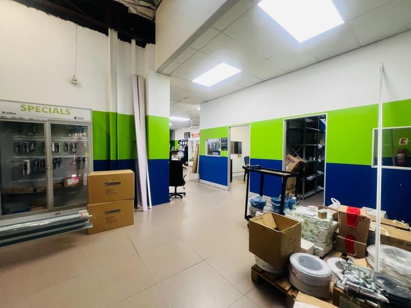 Commercial utility or retail space featuring tiled flooring, suspended ceiling with recessed lighting, and a built-in display cabinet.