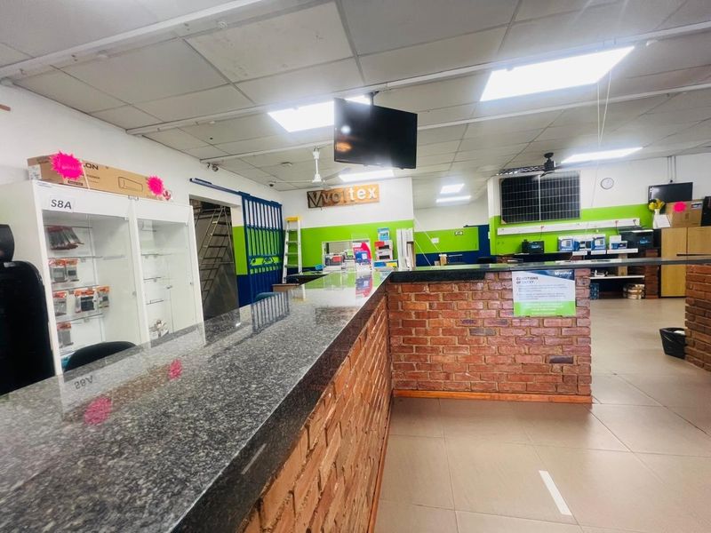 Commercial reception area featuring a granite-topped brick counter, suspended ceiling, and built-in display cabinetry in a functional retail or office environment.