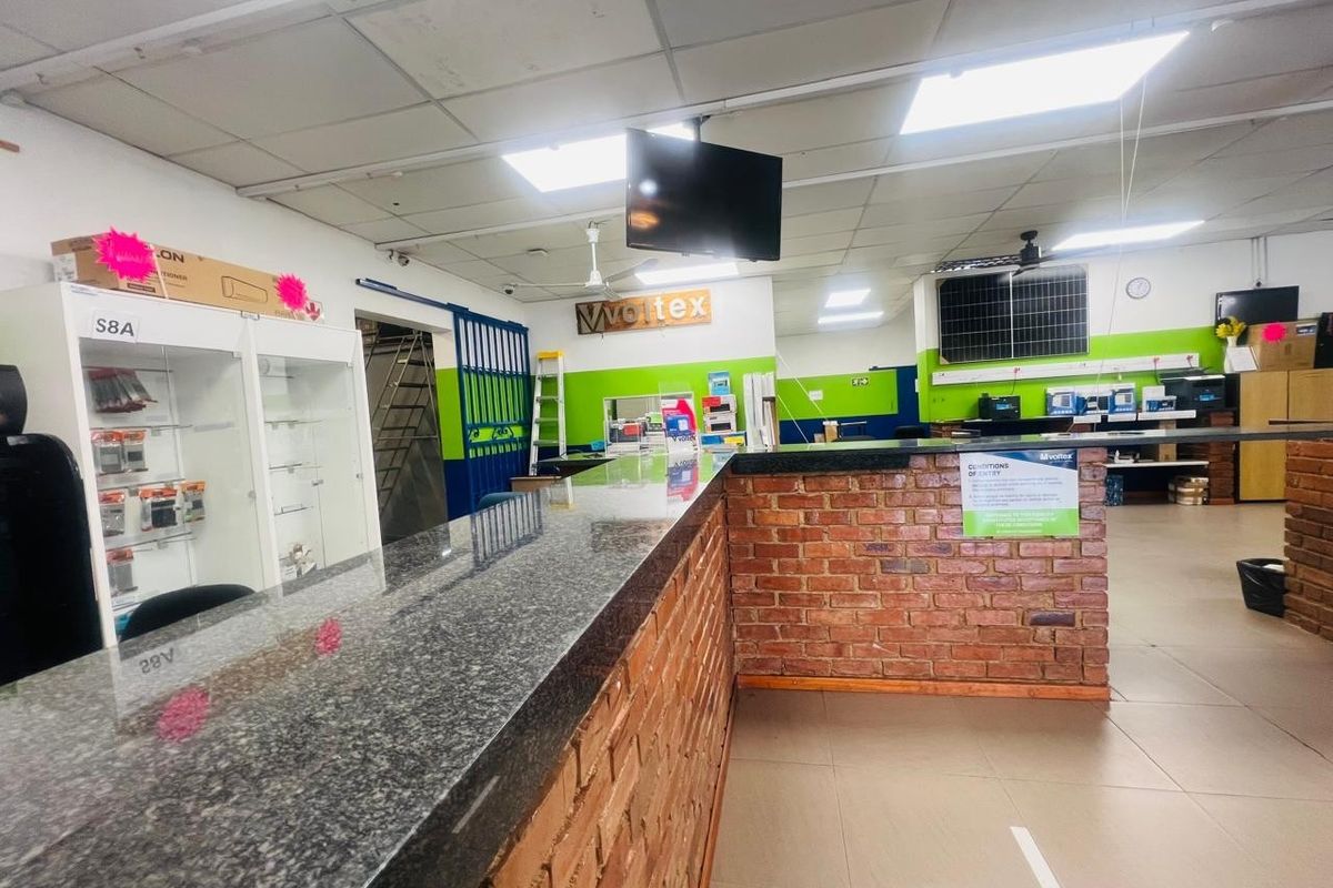 Commercial reception area featuring a granite-topped brick counter, suspended ceiling, and built-in display cabinetry in a functional retail or office environment.