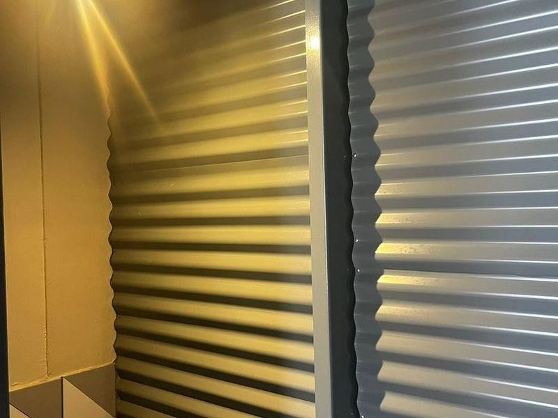 A close-up view of interior wall finishes featuring corrugated metal cladding and geometric patterned tiling.