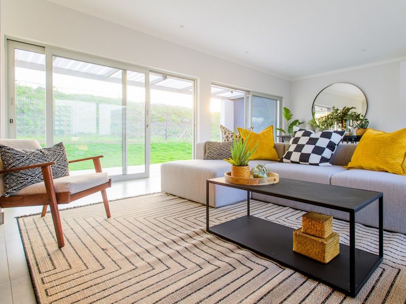 Bright and modern living room featuring large sliding glass doors that provide seamless access to the outdoor area and abundant natural light.