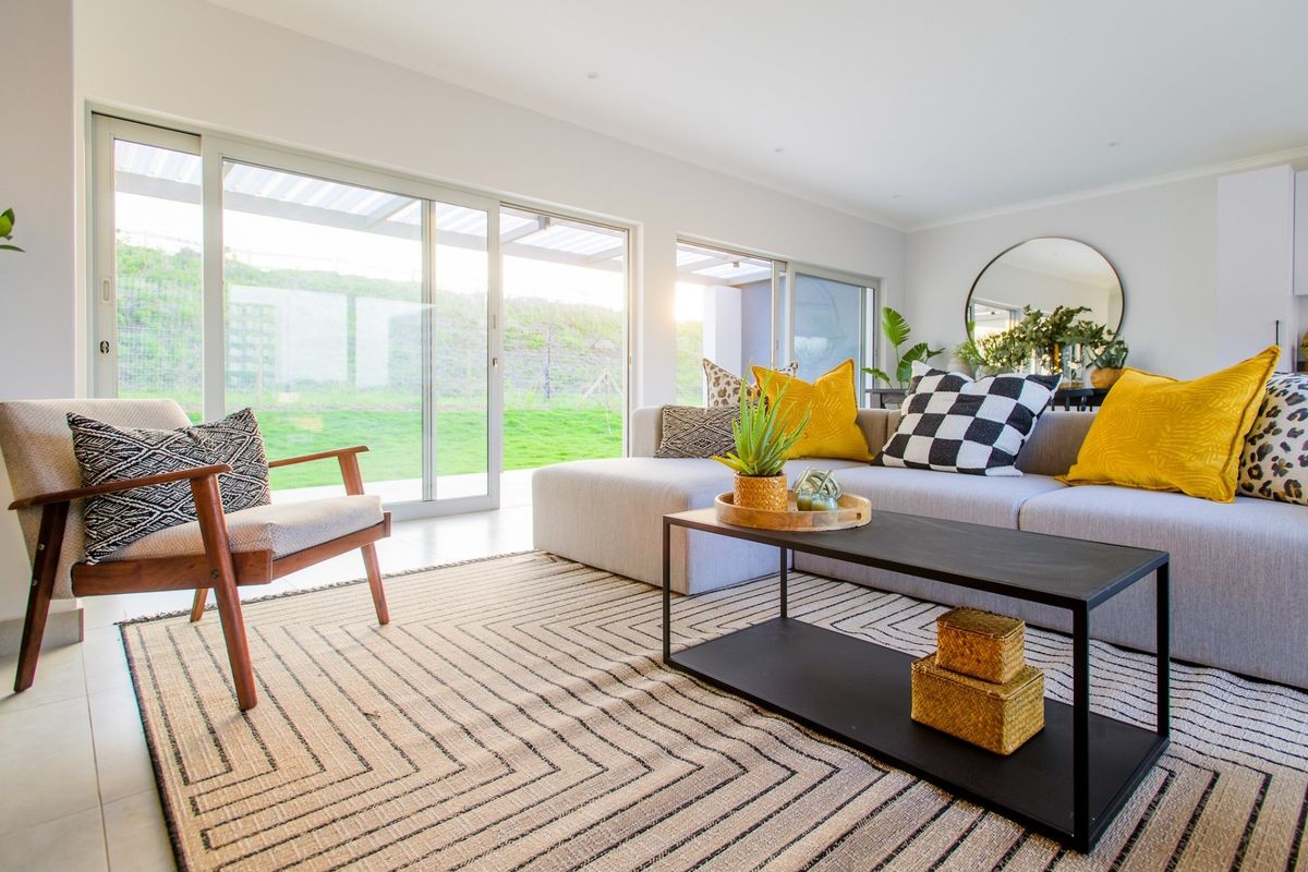 Bright and modern living room featuring large sliding glass doors that provide seamless access to the outdoor area and abundant natural light.