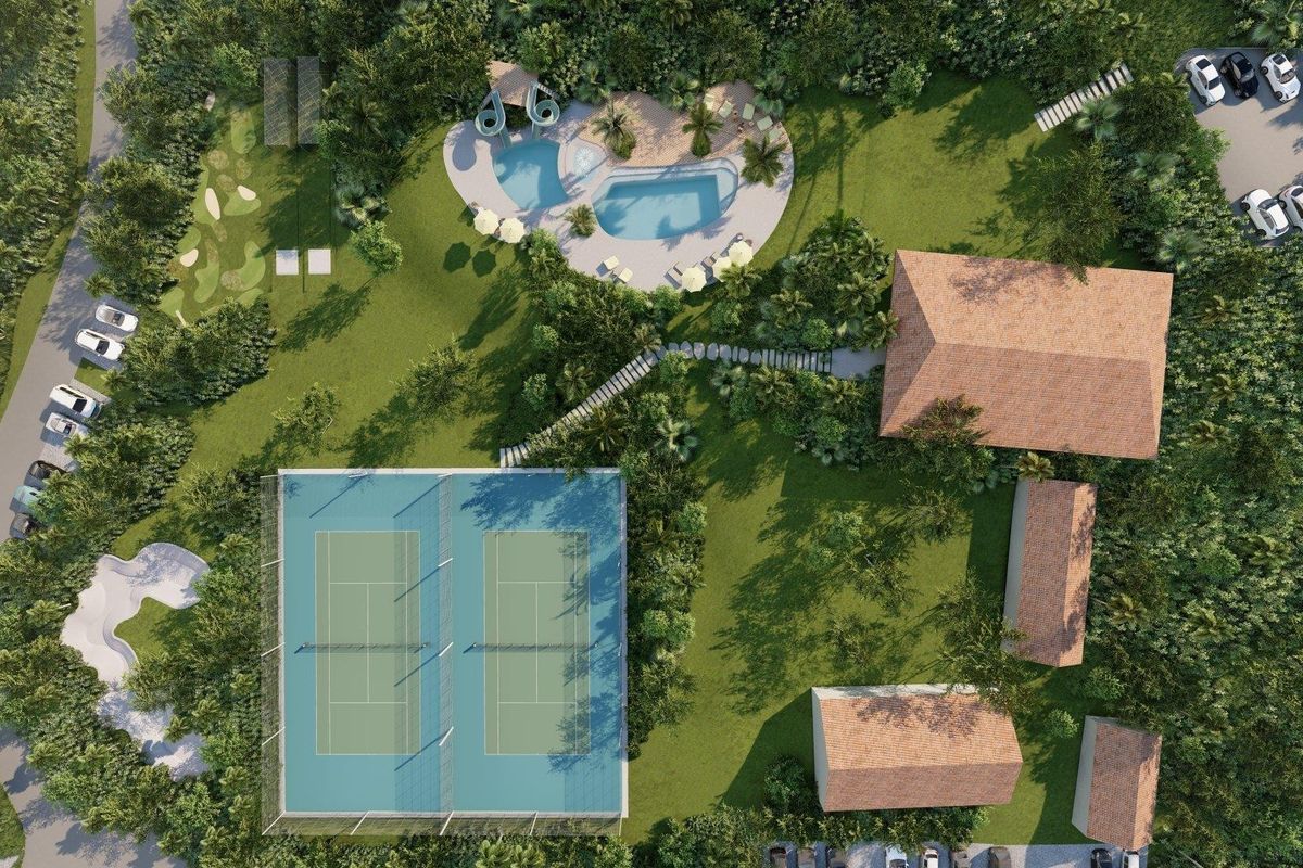 An aerial view of the property grounds featuring tennis courts, a swimming pool, landscaped gardens, and multiple residential structures with tiled roofs.