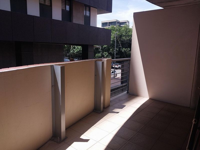 A private balcony featuring tiled flooring and a metal balustrade, offering an open outdoor space for relaxation.