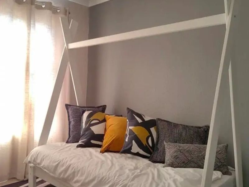 A well-maintained bedroom featuring neutral grey walls and classic cove cornicing, providing a clean and simple living space.
