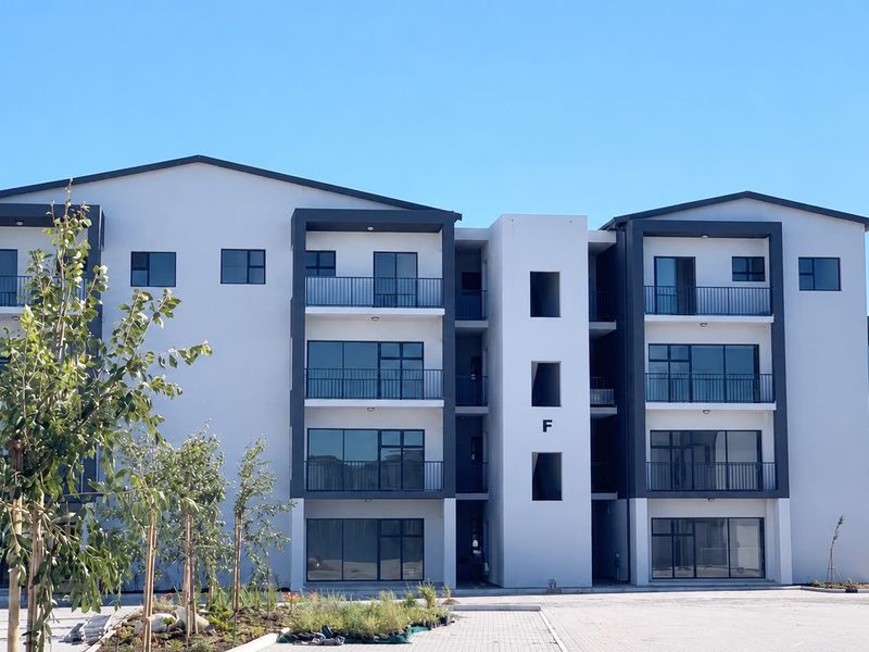 Modern multi-story townhouse complex featuring contemporary architecture, private balconies with metal railings, and large glass sliding doors.