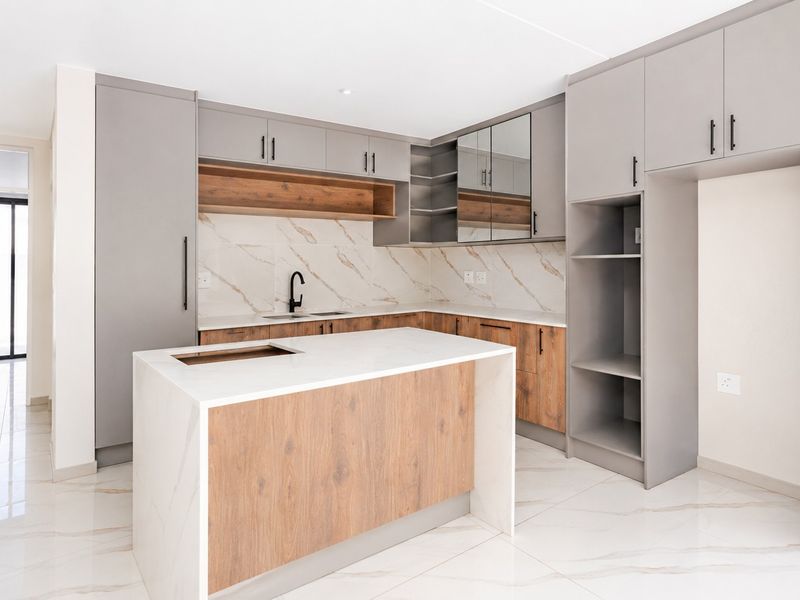 Modern kitchen featuring a central island, quartz countertops, marble-look tile backsplash, and sleek two-tone cabinetry with high-quality finishes.