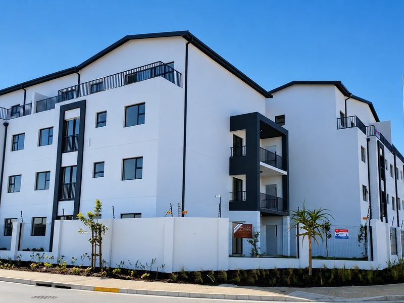 Modern multi-story townhouse complex featuring white facade, black trim, private balconies, and secure perimeter wall with electric fencing.