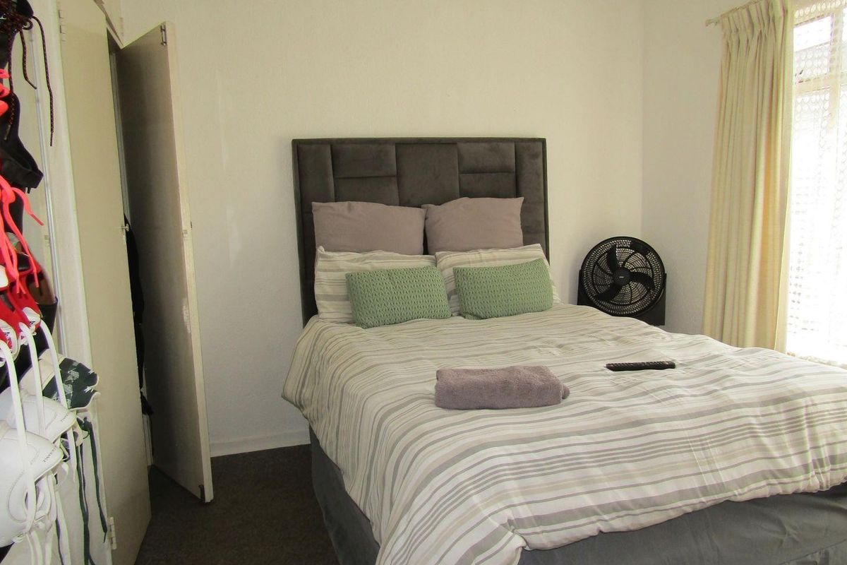 A standard bedroom featuring carpeted flooring and a built-in wardrobe, providing functional storage space within the apartment.
