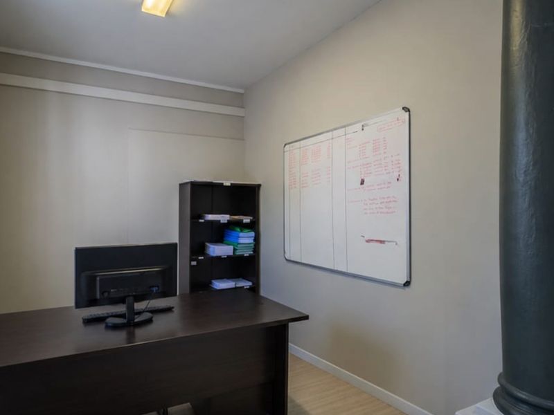 A functional office space featuring neutral wall finishes and a prominent structural column, suitable for a dedicated workspace or study area.