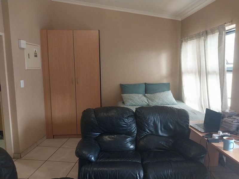 A bedroom featuring tiled flooring, a built-in wardrobe, and an integrated electrical distribution board.
